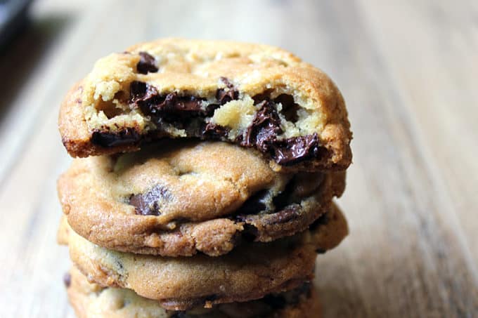 Jacques Torres Chocolate Chip Cookies in a stack with a bite out of top cookie