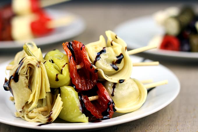 Italian Antipasto Skewers: The spice of the pepperoni, the sweet vinegar of the balsamic glaze, the tender tortellini filled with ricotta and spinach, the briney flavor of the pepperoncini and the artichoke heart. This skewer is going to be a solid contender for favorite bite at your next party! 