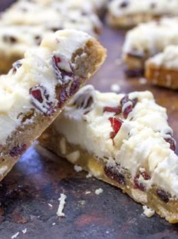 Starbucks White Chocolate Cranberry Bliss Bars are a delicious blondie cookie bar with white chocolate topped with sweet cream cheese icing, tart dried cranberries, and a sweet white chocolate orange drizzle.