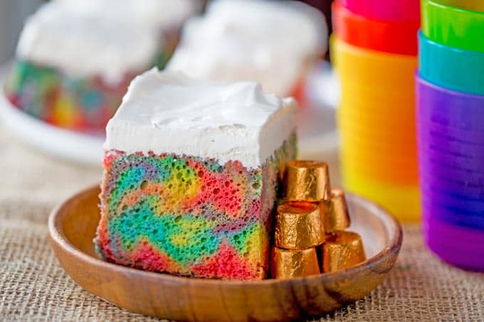 Rainbow Poke Cake With Whipped Cream made with no cake mix. Condensed milk makes this poke cake super moist and fluffy stabilized whipped cream won't melt!