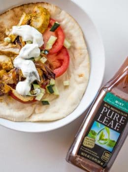 Chicken Shawarma Pita Wraps with Dill Yogurt Sauce are baked on a sheet pan with sweet red onions and wrapped in a pita for the ultimate lunch without the long lines at your favorite lunch restaurant.
