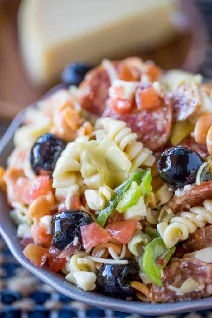 Italian Antipasto Pasta Salad is delicious and easy with creamy Italian dressing, cheese, salami, olives, tomatoes, bell peppers and pasta that's the perfect addition to your summer menus!