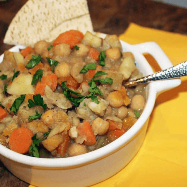 bowl of stew in white bowl served with pita chips