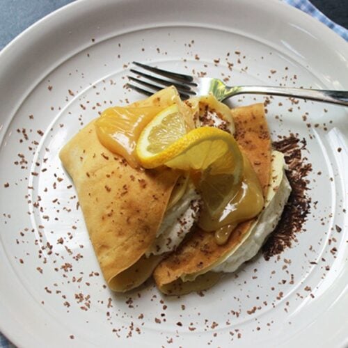Plated crepes with lemon curd on top.