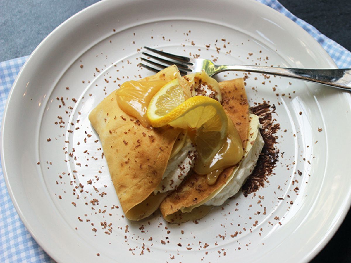 My Chocolate Lemon Curd Crepes are perfect for a special breakfast and surprisingly easy to make. You can even prep the batter ahead of time! Plated crepes with lemon curd on top.
