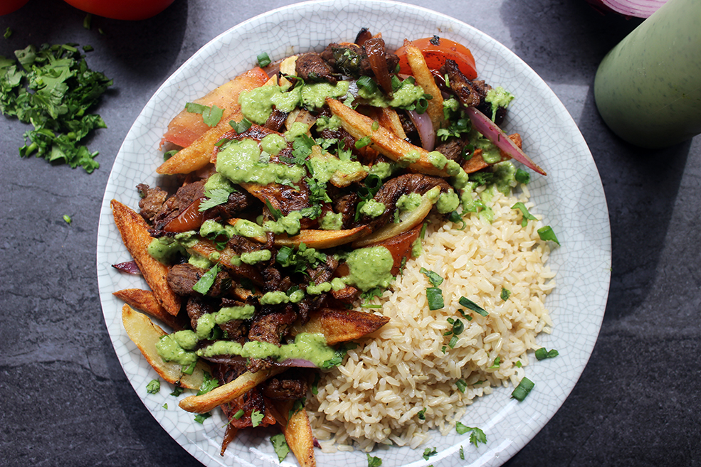 El Pollo Inka's most popular entree, Lomo Saltado, is sliced steak, onions, tomatoes, fries and cilantro topped with spicy green aji sauce and brown rice.