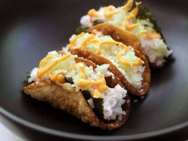 3 crunchy tacos on plate with sushi filling