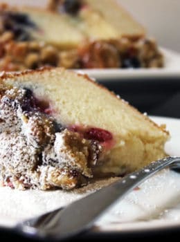 Sweet & Tangy Triple Berry Sour Cream Crumb Cake with Slivered Almonds. A delicious summer treat with the ripest sweetest fruit. The cake is tangy from the sour cream, sweet from the berries and crispy from the topping.