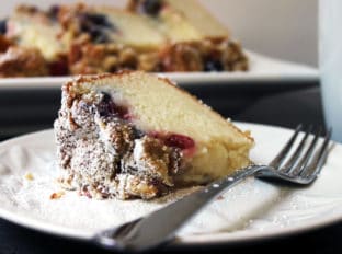 Sweet & Tangy Triple Berry Sour Cream Crumb Cake with Slivered Almonds. A delicious summer treat with the ripest sweetest fruit. The cake is tangy from the sour cream, sweet from the berries and crispy from the topping.