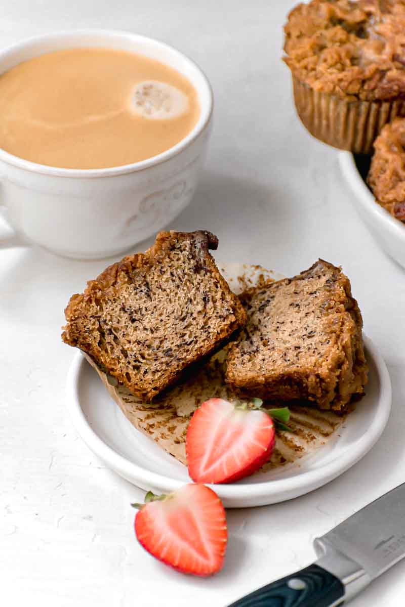 Banana Crumb Muffins sliced in half on plate with strawberry garnish