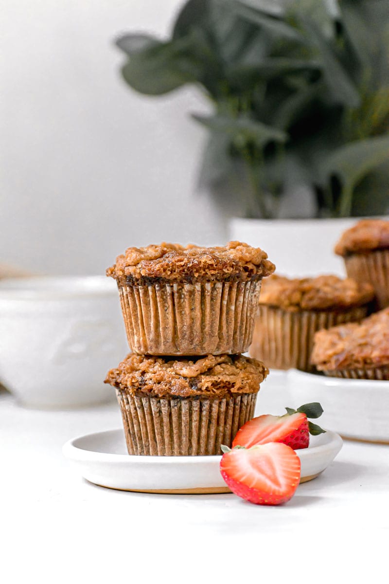 Banana Crumb Muffins stacked on plate with strawberry garnish