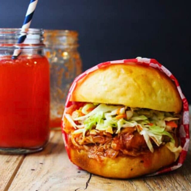 Chicken sandwich next to a red drink