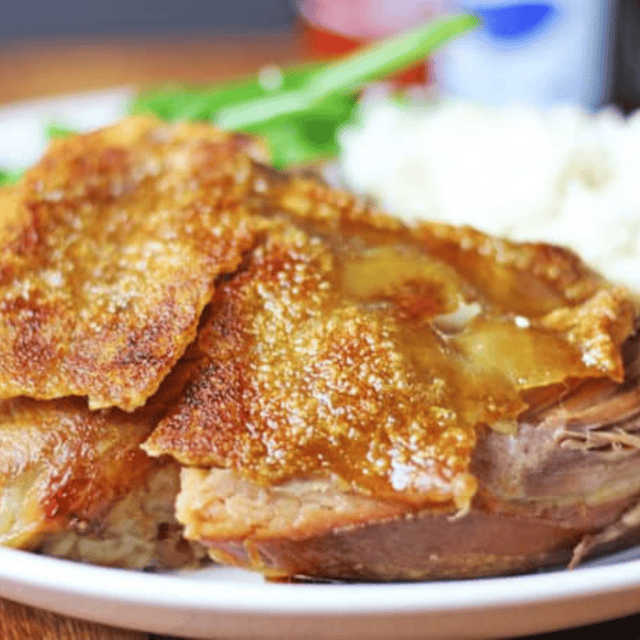 pork on a plate with potatoes and green beans