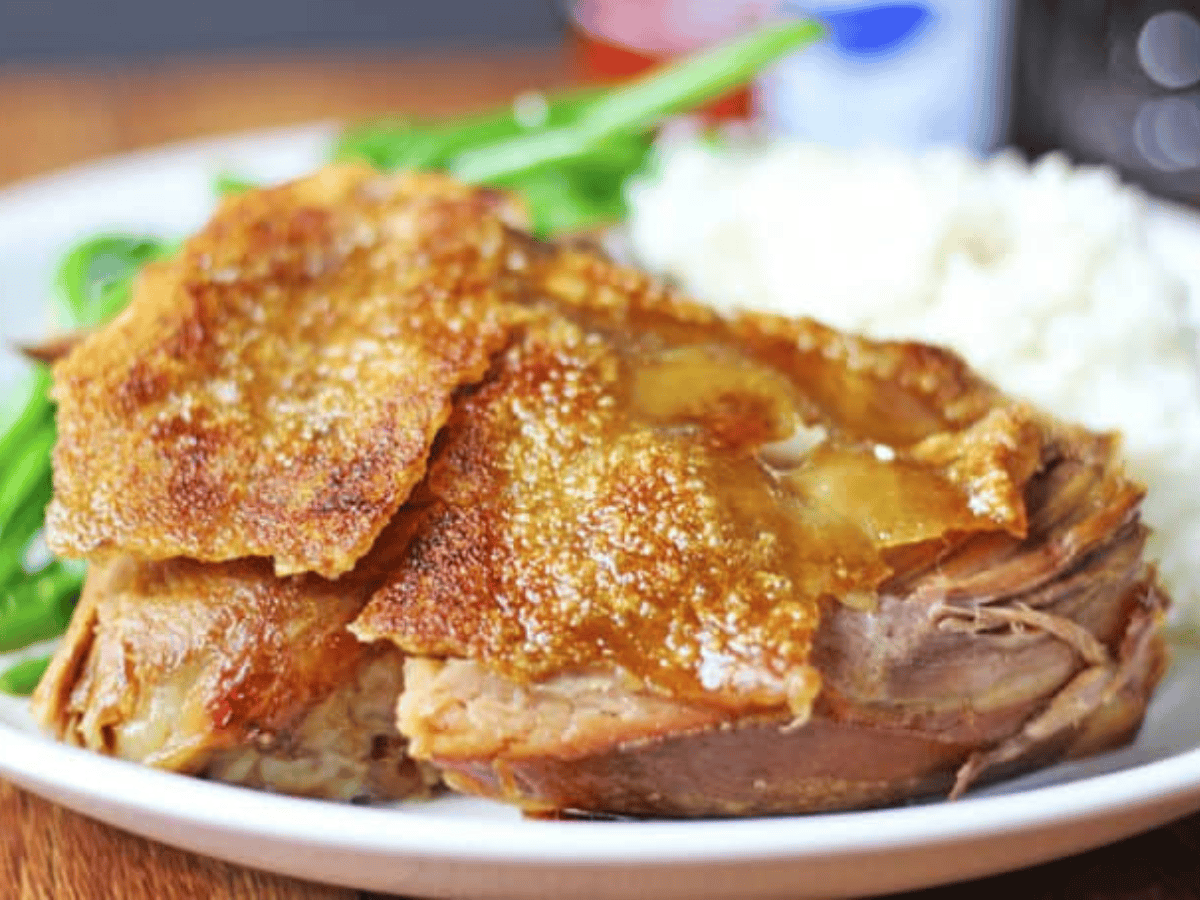 pork on a plate with potatoes and green beans 