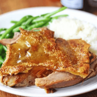 Plated pork pieces with gravy, green beans and mashed potatoes