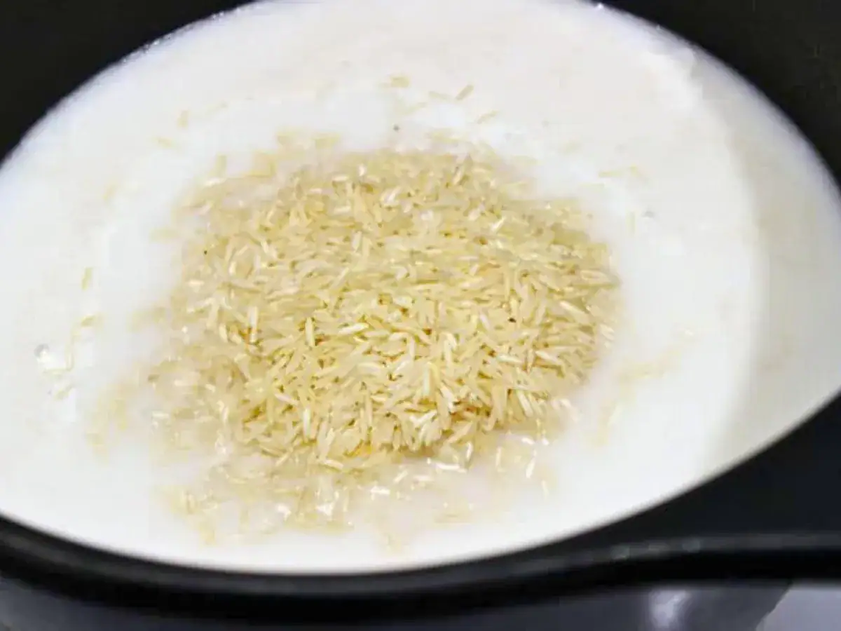 Uncooked rice in pot with broth