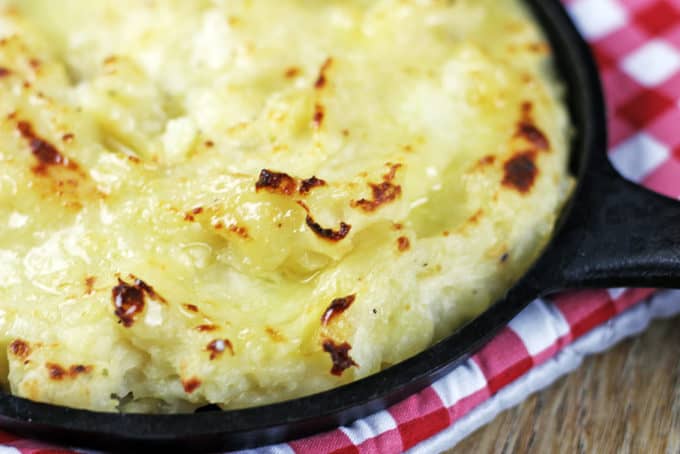 The richest mashed potatoes with five kinds of dairy! They are tangy, cheesy, rich and creamy with a deliciousy crisp crust out of the oven.