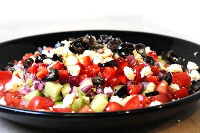 A delicious Greek Vegetable salad in a rainbow of colors. Fresh and healthy it is topped with salty rich feta and kalamata olives. Less than 200 calories a serving, eat the rainbow!