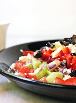A delicious Rainbow Greek Vegetable salad in a rainbow of colors. Fresh and healthy it is topped with salty rich feta and kalamata olives. Less than 200 calories a serving, eat the rainbow!
