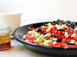 A delicious Rainbow Greek Vegetable salad in a rainbow of colors. Fresh and healthy it is topped with salty rich feta and kalamata olives. Less than 200 calories a serving, eat the rainbow!