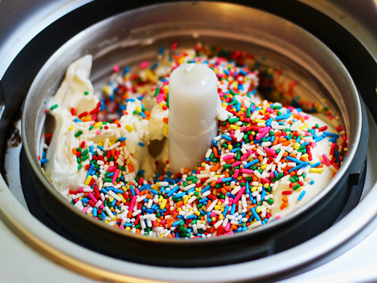 white ice cream covered in colorful sprinkles in a ice cream maker