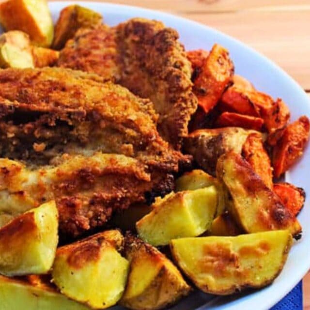 Fried chicken on a white plate with potatoes