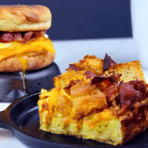 Slice of breakfast casserole with sandwich in the background