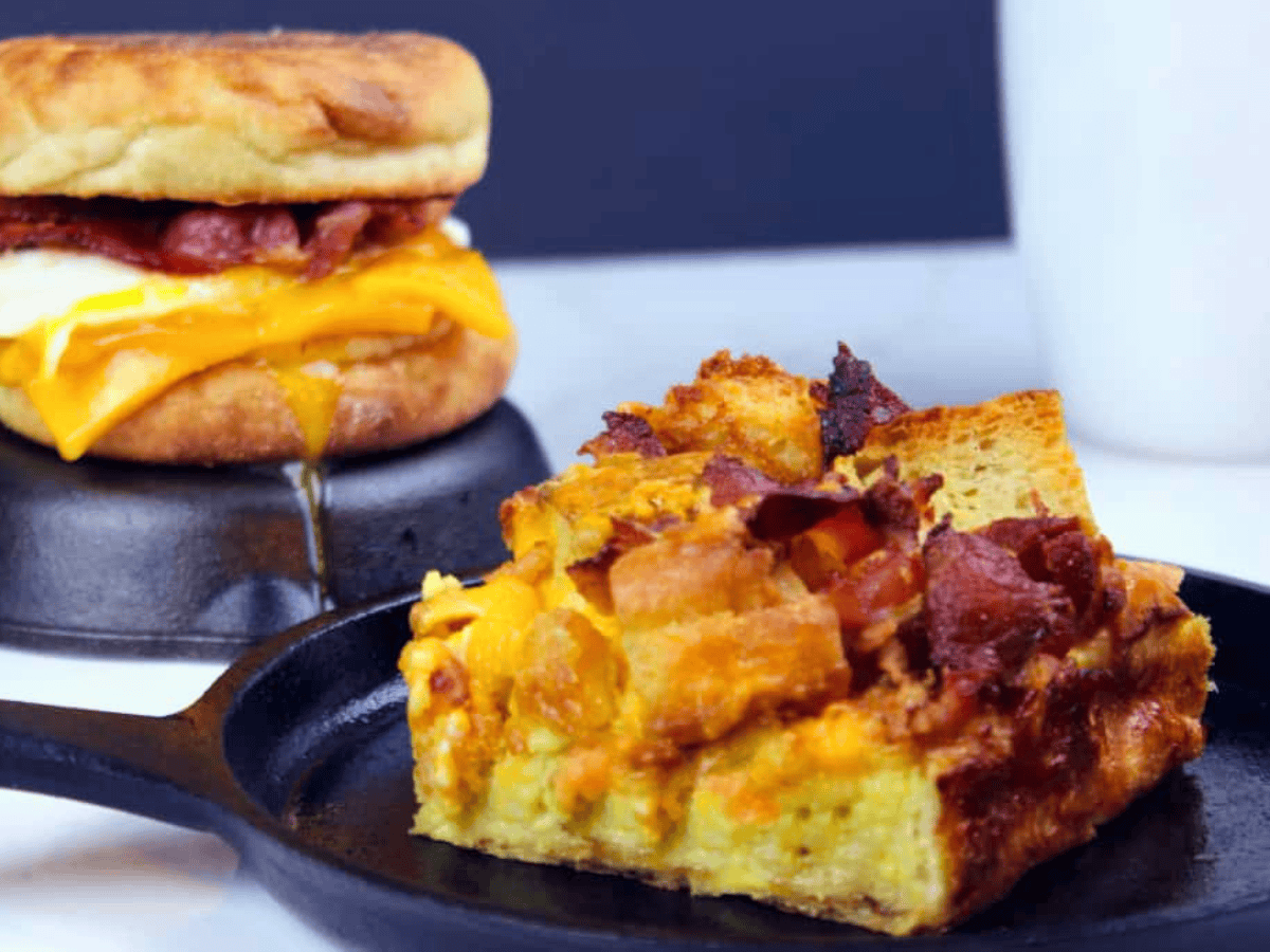 Slice of breakfast casserole with sandwich in the background