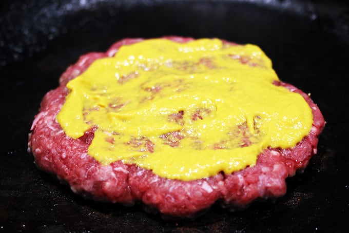 raw patty on pan cooking