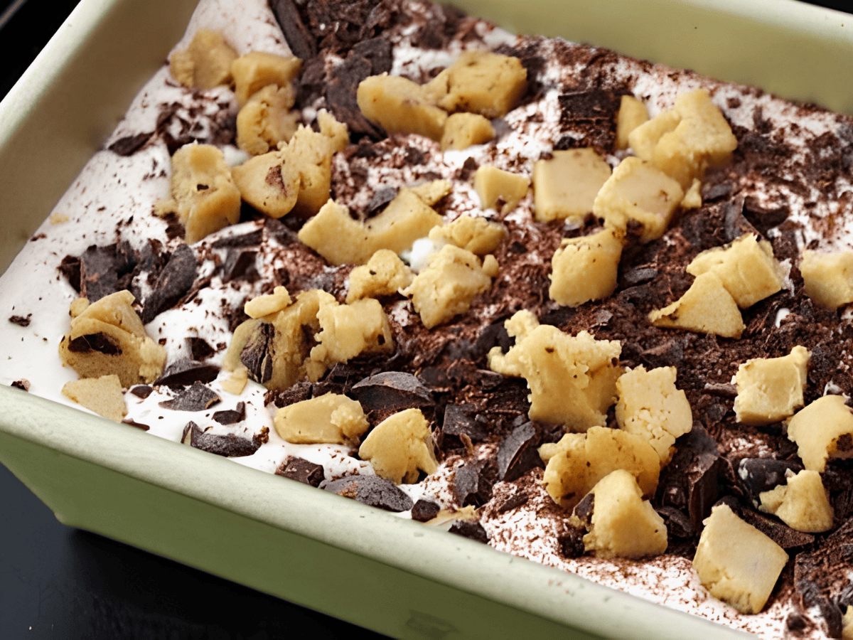 unbaked dough and cocoa on top of bed of ice cream in freezer tray