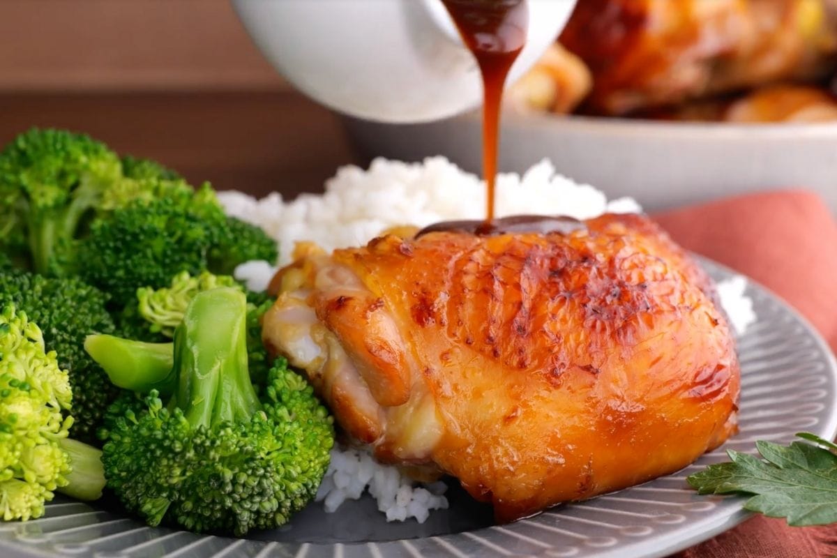 Classic Baked Teriyaki Chicken on plate with broccoli and white rice with sauce poured on