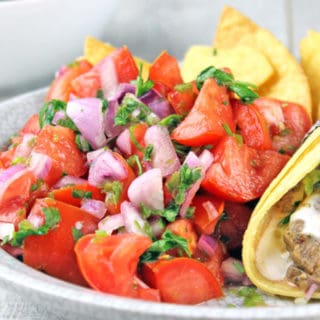 Pico de Gallo salad made with fresh tomatoes, red onions, jalapenos, cilantro and lime juice. You would expect it to be spicy, but the flavors work perfectly and this dish stands out as a delicious side to a great Mexican meal. Go ahead and add some cheese to your tacos because this salad has no fat!! You could eat the whole bowl completely guilt free!