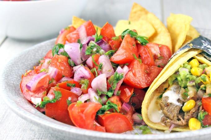 Pico de Gallo salad made with fresh tomatoes, red onions, jalapenos, cilantro and lime juice. You would expect it to be spicy, but the flavors work perfectly and this dish stands out as a delicious side to a great Mexican meal. Go ahead and add some cheese to your tacos because this salad has no fat!! You could eat the whole bowl completely guilt free!