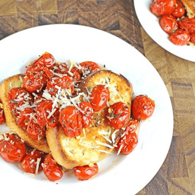 tomatoes and toast on a dish with cheese on top