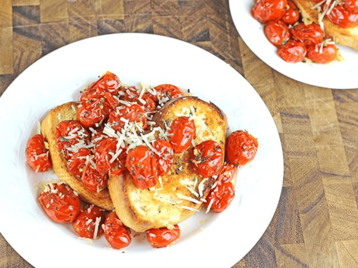 tomatoes and toast on a dish with cheese on top