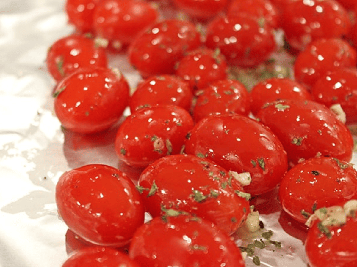 tomatoes seasoned and on a baking sheet