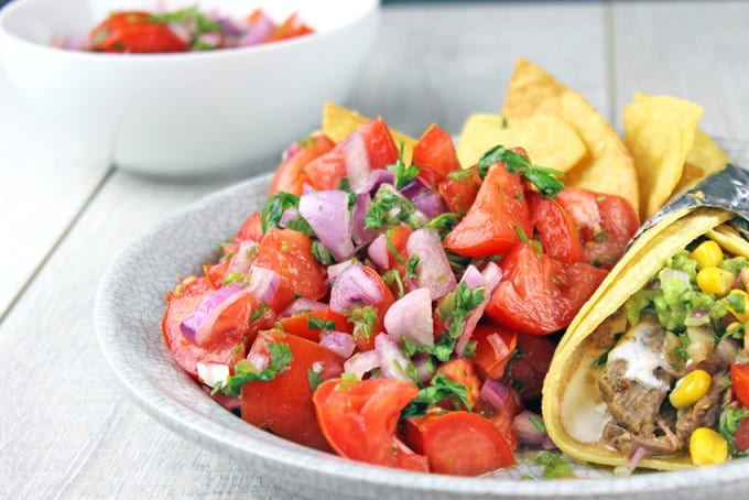 Pico de Gallo salad made with fresh tomatoes, red onions, jalapenos, cilantro and lime juice. You would expect it to be spicy, but the flavors work perfectly and this dish stands out as a delicious side to a great Mexican meal. Go ahead and add some cheese to your tacos because this salad has no fat!! You could eat the whole bowl completely guilt free!