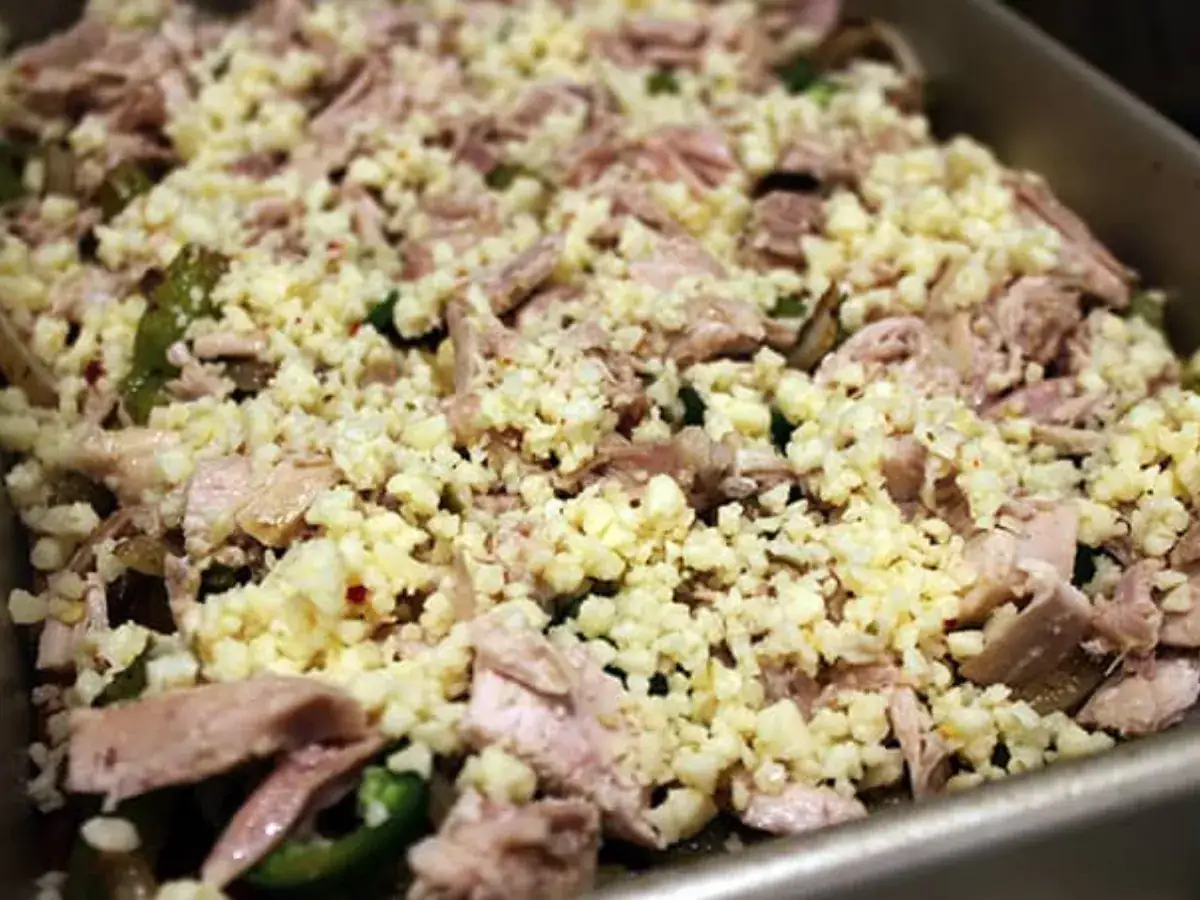raw chicken and veggies spread out on a sheet pan