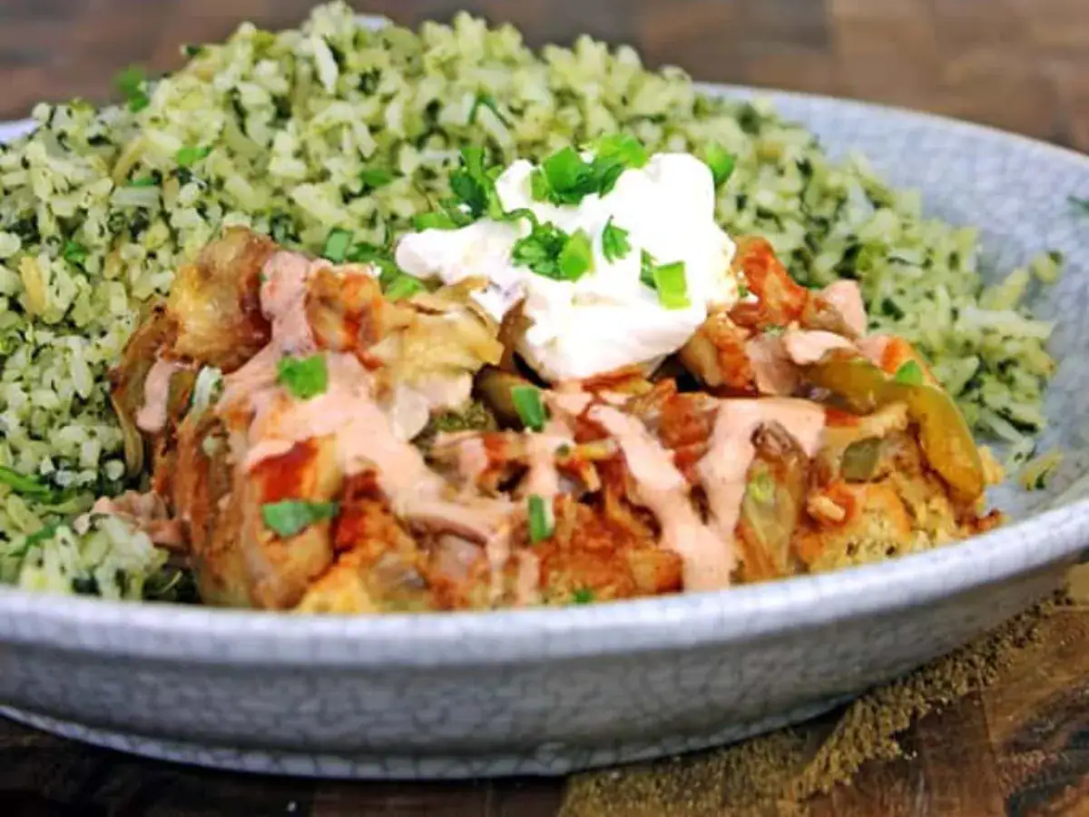 chicken and rice meal on a plate with sour cream on top