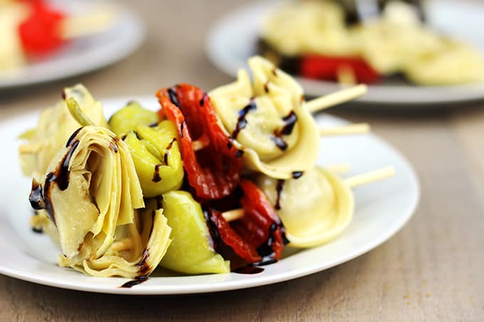 Italian Antipasto Skewers: The spice of the pepperoni, the sweet vinegar of the balsamic glaze, the tender tortellini filled with ricotta and spinach, the briney flavor of the pepperoncini and the artichoke heart. This skewer is going to be a solid contender for favorite bite at your next party! 