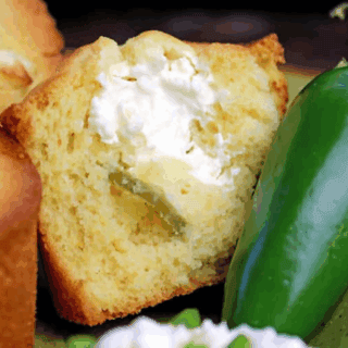 Muffin broken open with whole jalapeno, cream cheese and dice jalapenos on side