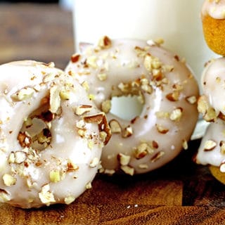 Baked Mini Pumpkin Donuts with Maple Icing. Tender Pumpkin baked donuts that are made in one bowl and bake in 8 minutes are covered in a quick two ingredient maple icing and finally are topped with crunchy pecans. It will look like you're a pro in the kitchen but these are a cinch to make!