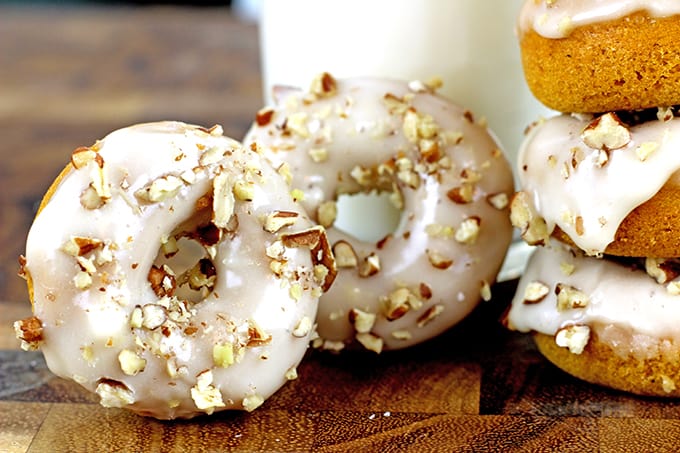 Baked Mini Pumpkin Donuts with Maple Icing. Tender Pumpkin baked donuts that are made in one bowl and bake in 8 minutes are covered in a quick two ingredient maple icing and finally are topped with crunchy pecans. It will look like you're a pro in the kitchen but these are a cinch to make!