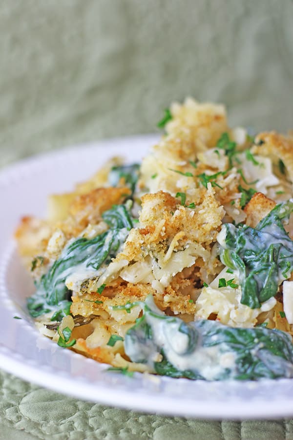 Your favorite Spinach and Artichoke Dip in a pasta bake with a Parmesan Buttery Cracker crust! Made with Mozzarella, Parmesan, cream cheese and sour cream with fresh spinach and artichoke hearts.