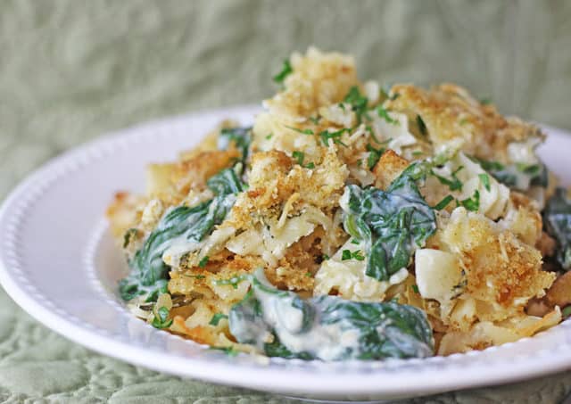 Spinach and artichoke pasta bake topped with buttery crackers.
