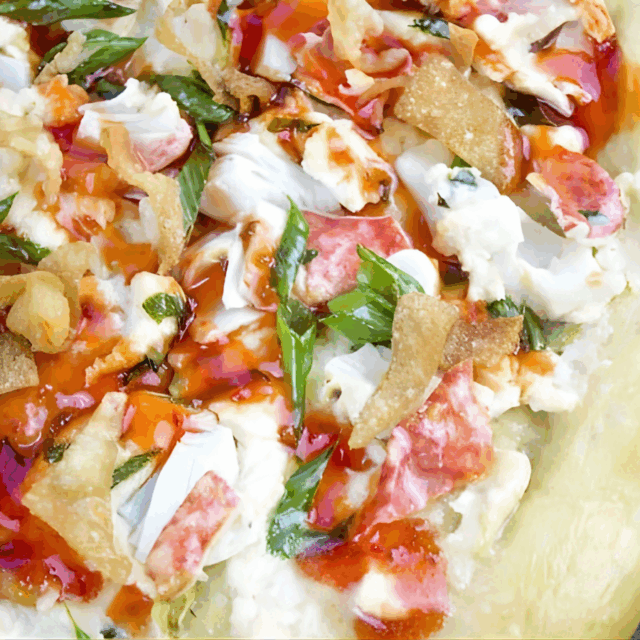 seafood meat, dairy, wonton chips, and veggies on cooked dough