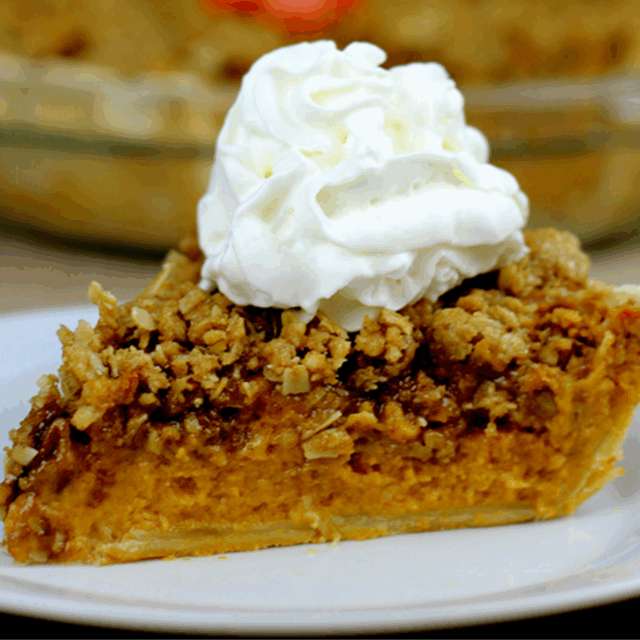 Slice of baked pie plated with whipped cream dollop