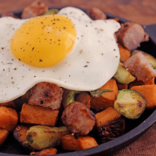 close up of egg and veggies cooking in skillet
