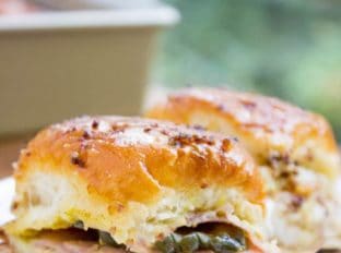 Baked Cuban Pork Party Sliders have pork shoulder, sliced ham, Swiss cheese, pickles, brown mustard and a butter whole grain mustard topping make these party sliders a perfect gameday treat and put the standard ham and cheese versions to shame.