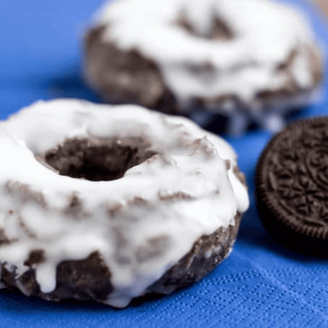 2 doughnuts covered in glaze with an oreo on the side